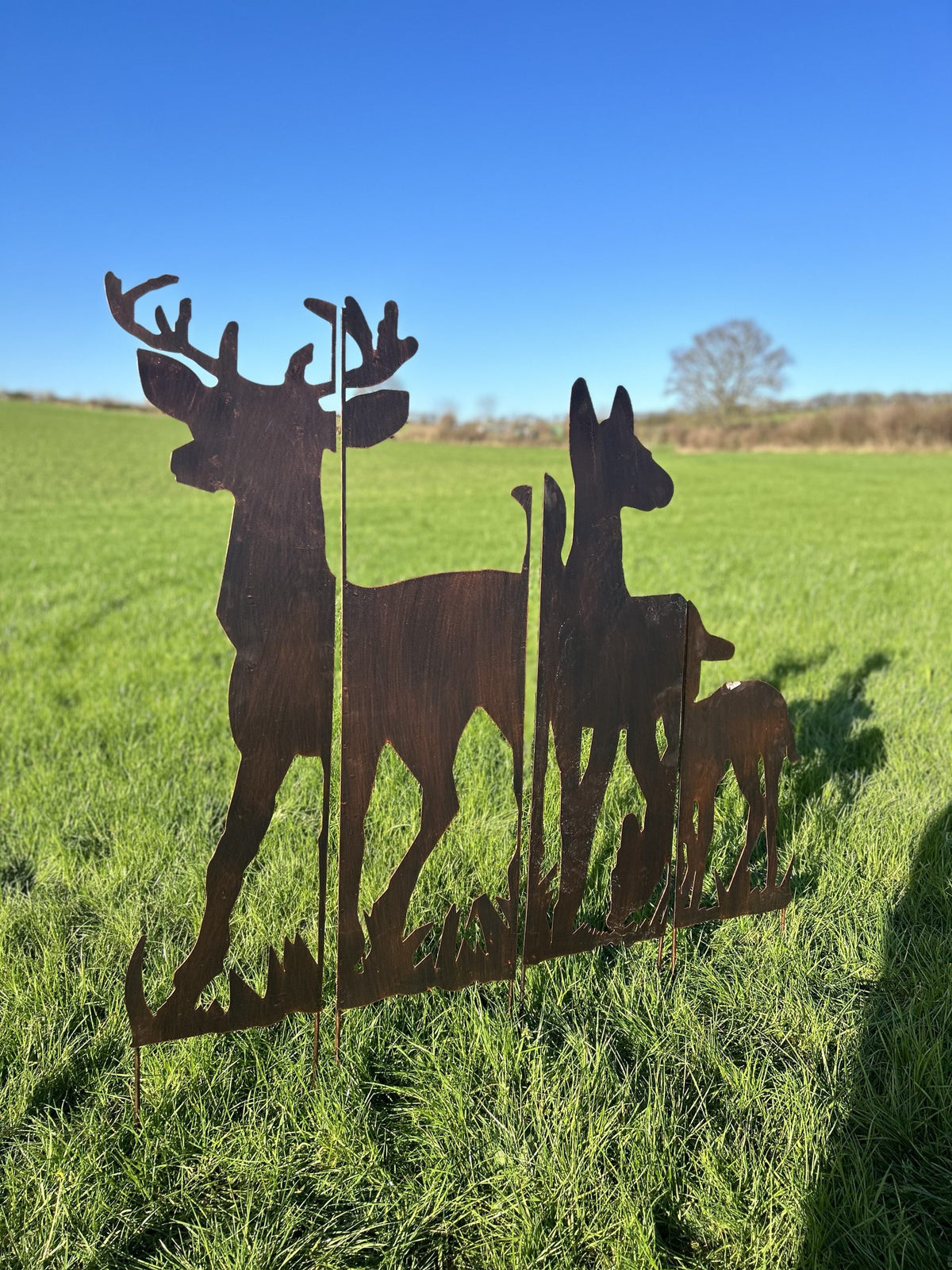 4 panel deer scene made from metal in field with grass and a tree 