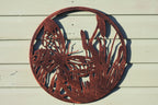 Decorative metal wall art with butterfly design on a wooden surface