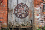 Rustic metal circular object on a wooden door with brick walls in the background