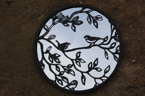 Decorative circular patch with bird and branch design on a dark background