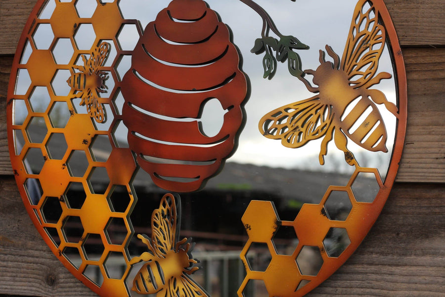 Decorative metal wall art with bees and a beehive on a wooden background