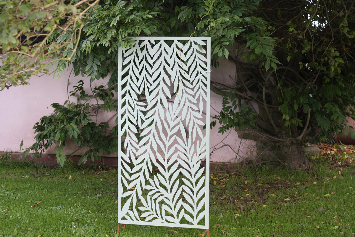 Decorative metal screen with leaf pattern in a garden setting