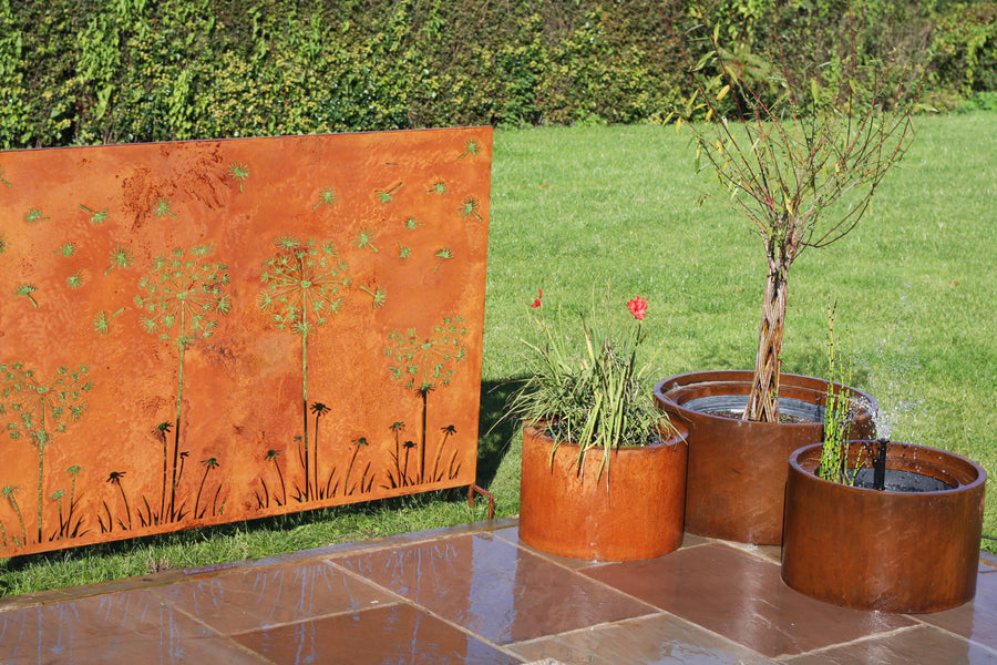 Corten steel planters and decorative screen in a garden setting
