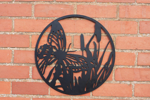 Decorative metal wall art of a butterfly and flowers on a brick wall.