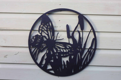 Decorative metal wall art of a butterfly and flowers on a wooden surface
