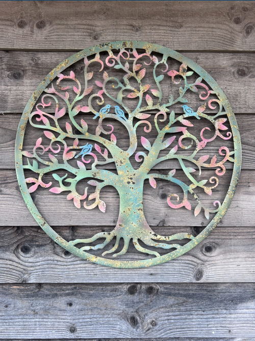 Decorative metal tree of life wall art on a wooden background