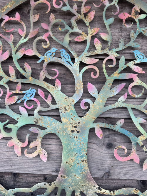 Decorative metal tree with colorful birds on a wooden background