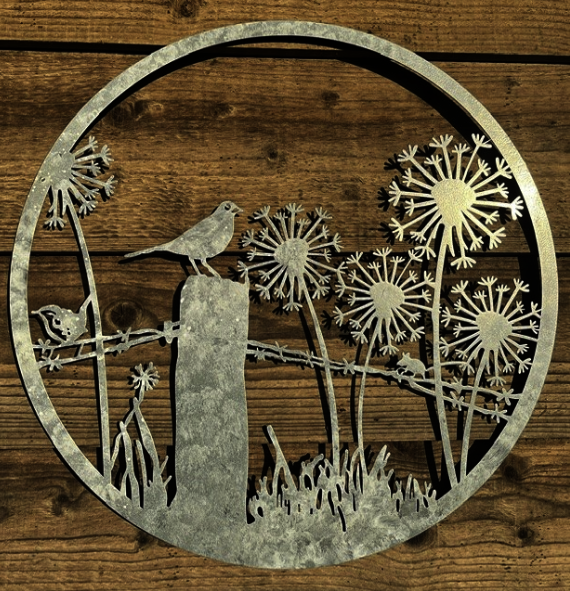Decorative metal wall art with birds and flowers on a wooden background